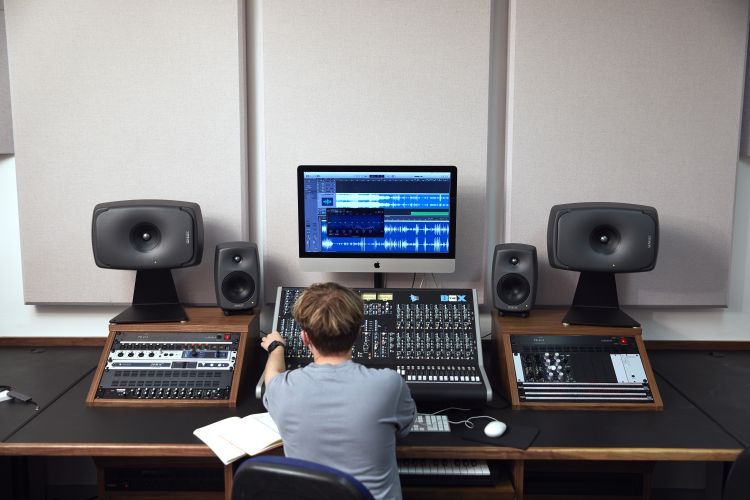 Electronic music student at a mixing desk in a studio